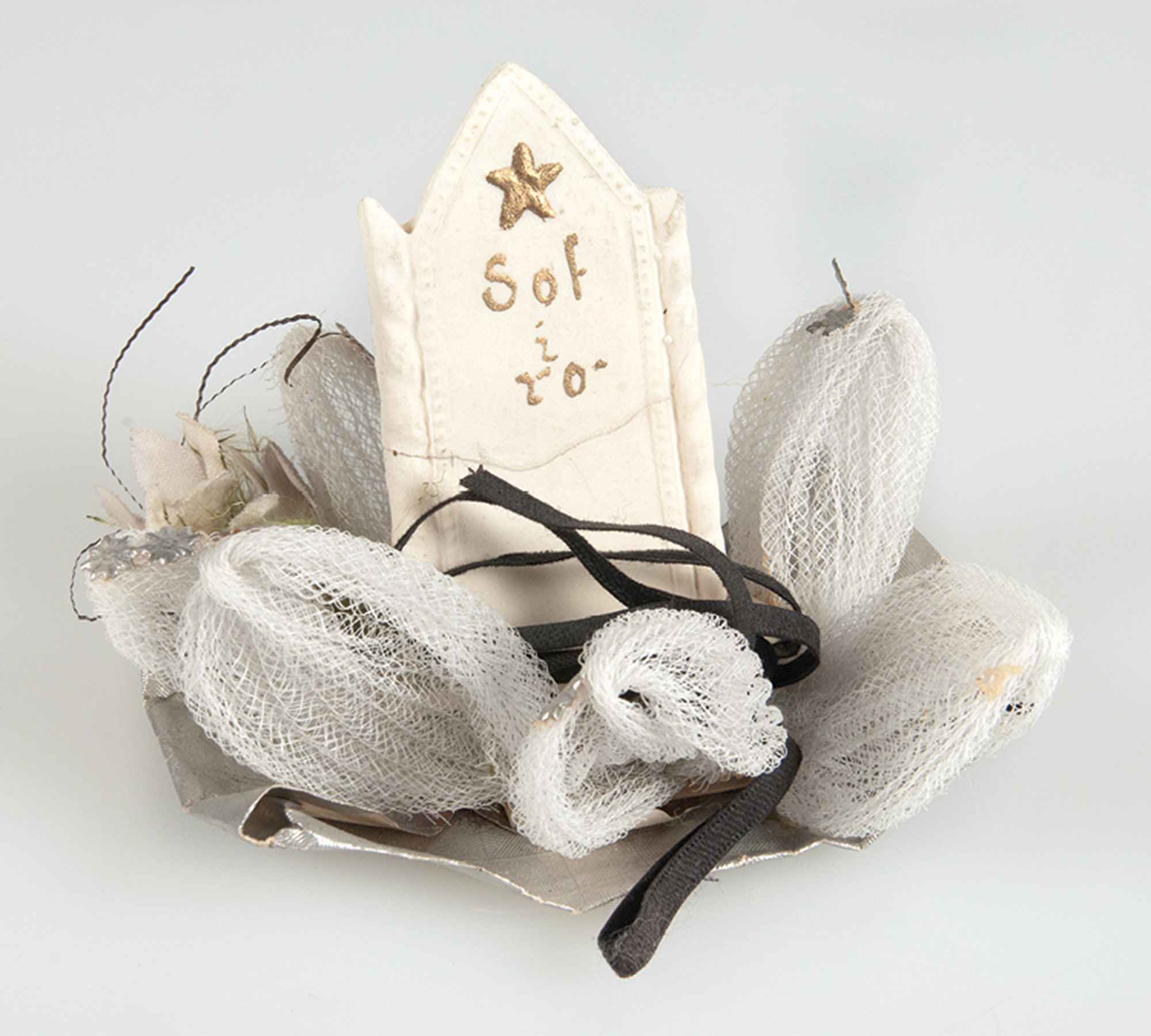 A photograph of a display for funeral candy, probably made in the early nineteen hundreds. The inscription on the sugar headstone reads, “Sleep in peace.”