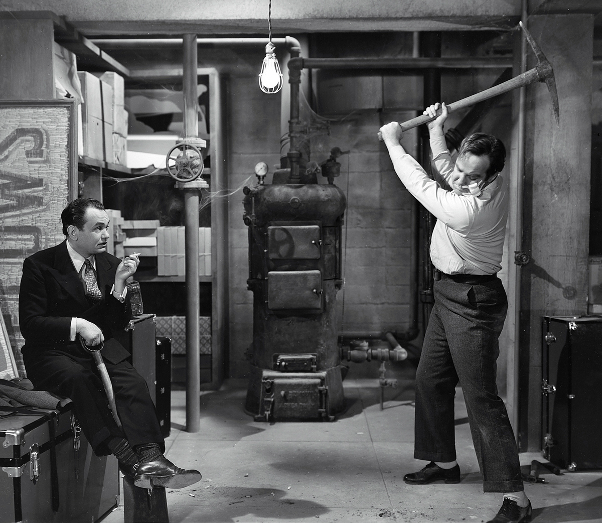 A film still from nineteen forty-two’s “Larceny, Inc.” It shows “Pressure” Maxwell (Edward G. Robinson) and Jug Martin (Broderick Crawford) getting to work on a bank burglary.