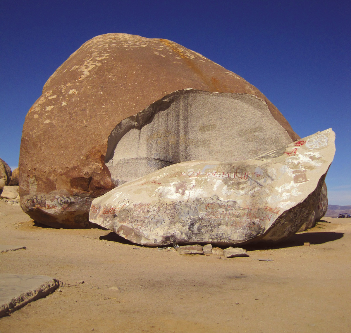 A photograph of Giant Rock today, covered in a number of graffiti tags.