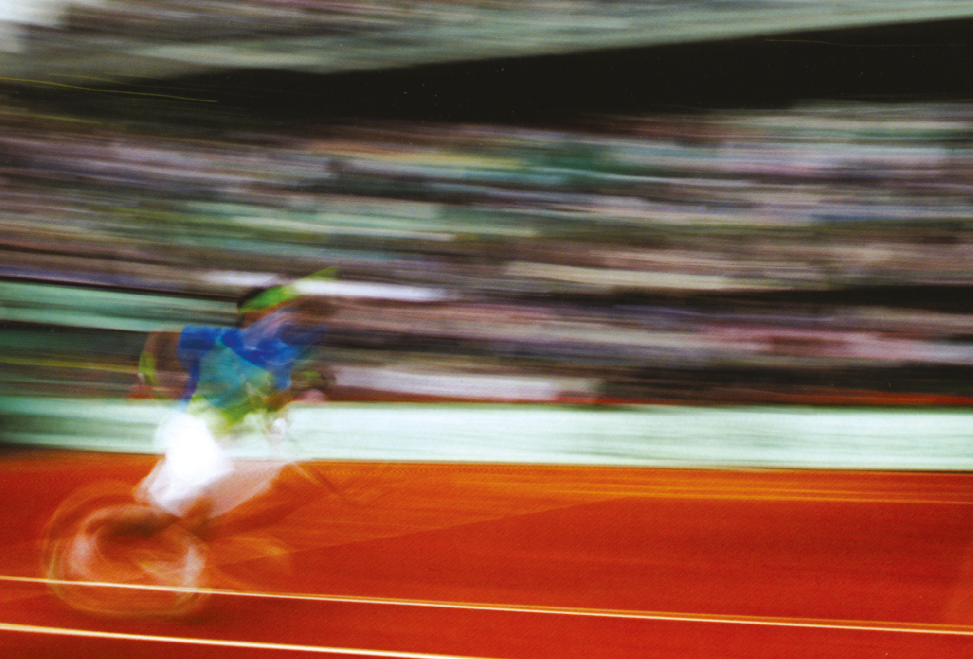A blurred photograph of Nadal running for a ball.