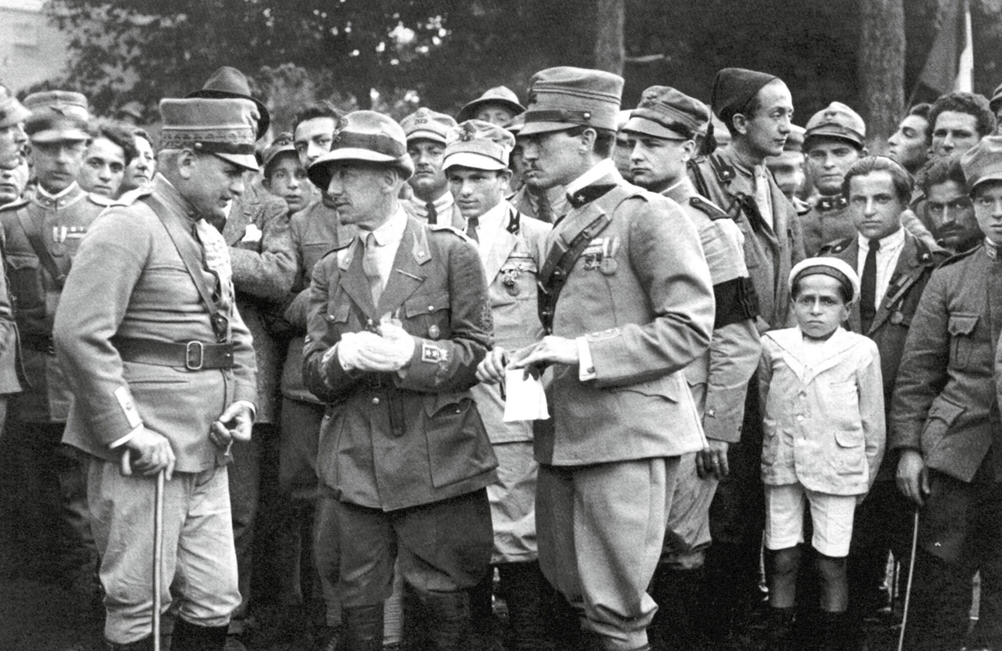 A photograph of D’Annunzio conferring with two of his military commanders, taken on the 30th of May nineteen twenty.