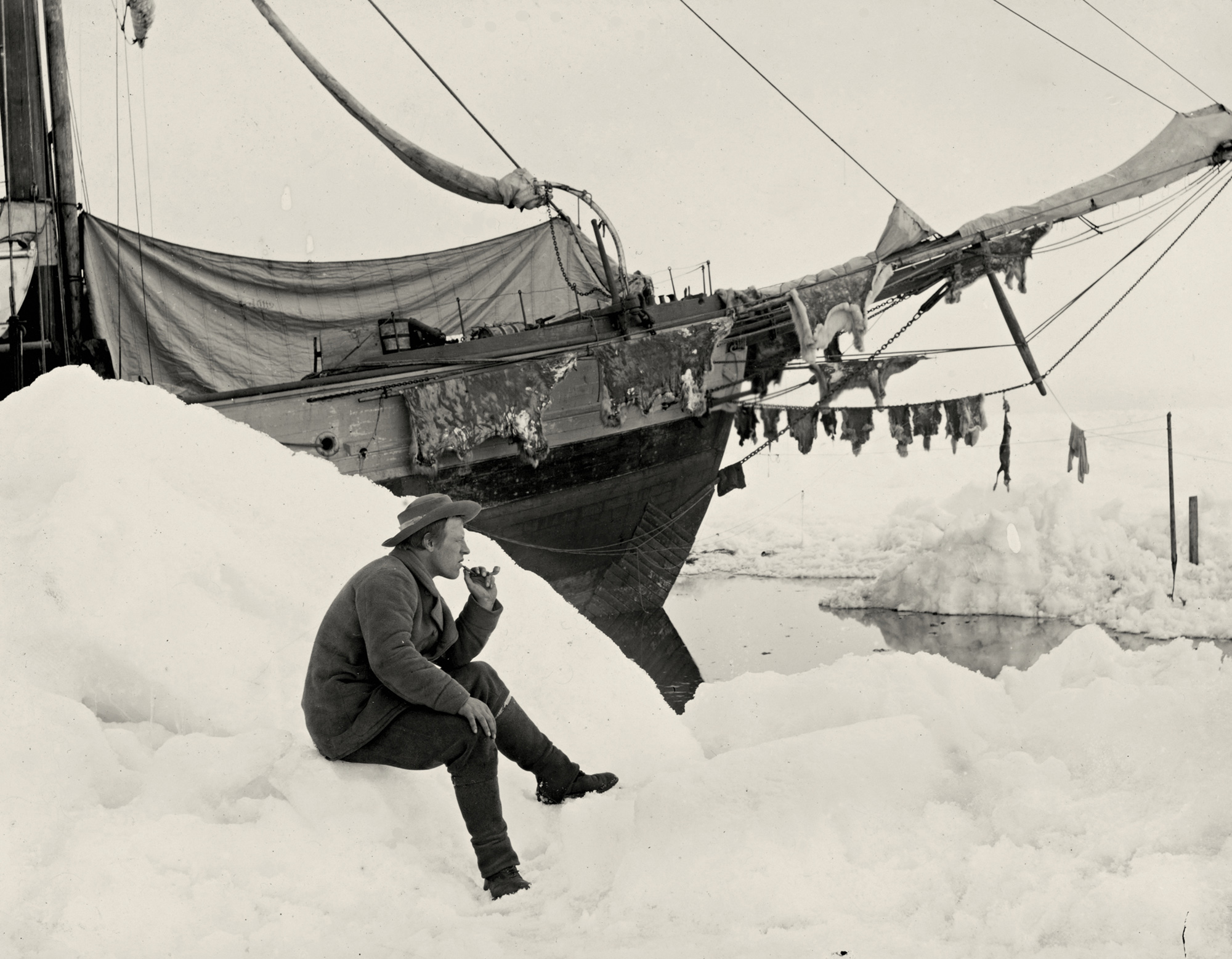 A photograph of Fridtjof Nansen smoking his pipe in front of the “Fram”, taken on the 16th of June eighteen ninety-four. When reproduced in “Farthest North,” Nansen’s account of his voyage, the photograph was labeled “Homesickness.”
