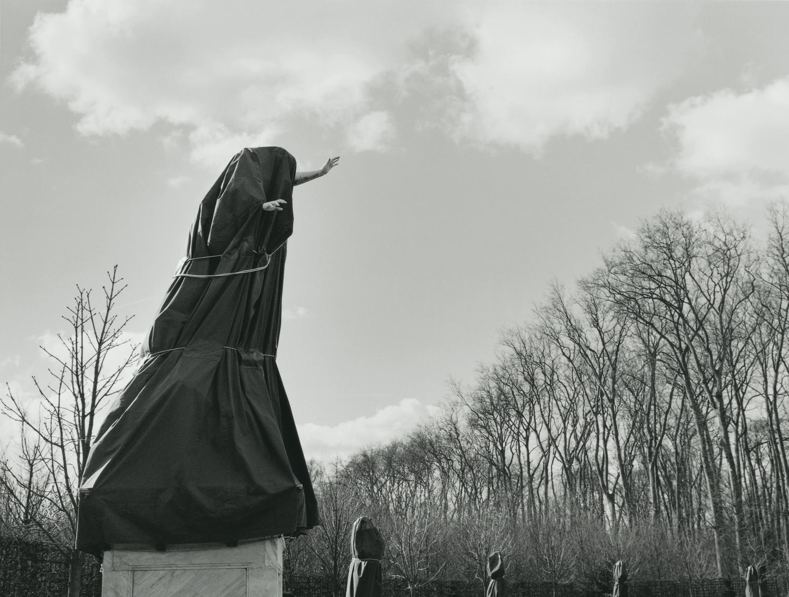 A 2001 photograph by artist Ann Burke Daly from her series “Anti-Monuments” depicting a sculpture in the gardens of Versailles covered with a tarp.