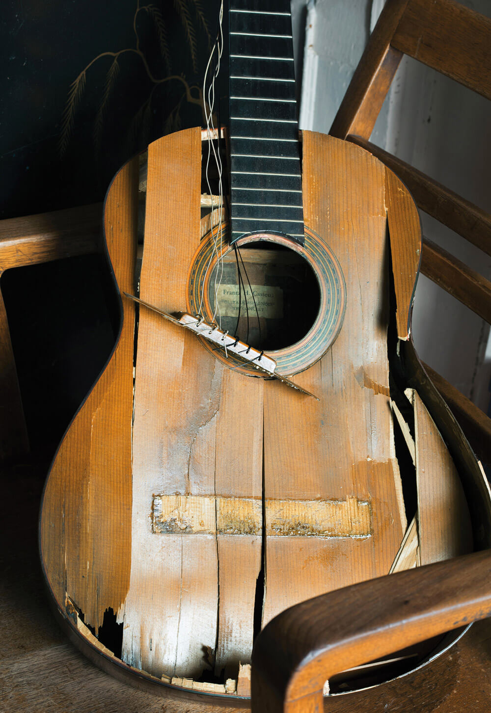 A photograph of a broken wooden electric guitar.