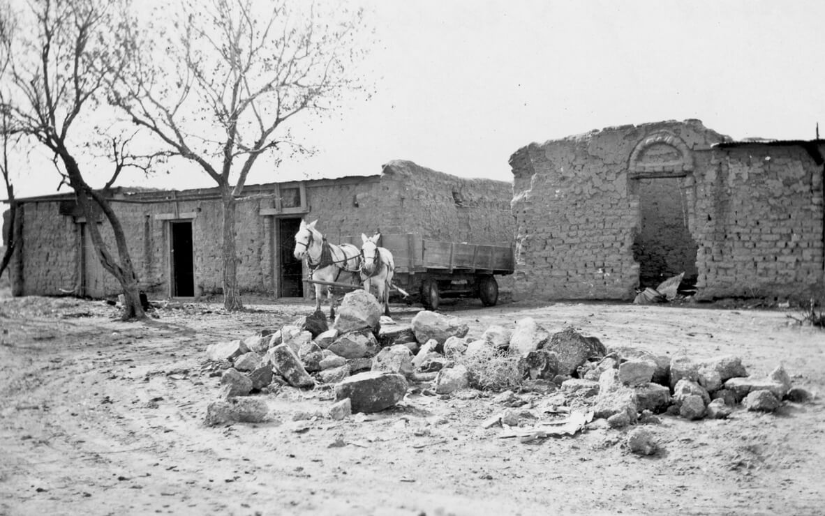 An undated photograph depicting the ruins of Shalam’s Fraternum, a dormitory building for the colony’s adults. A horse pulling a cart stands in front of the ruins. The mostly adobe structure contained more than forty rooms, including a kitchen and dining room, a library, and a laundry room, all built around a large central courtyard. As was the case with most buildings at Shalam, the front entrance to the Fraternum faced east.
