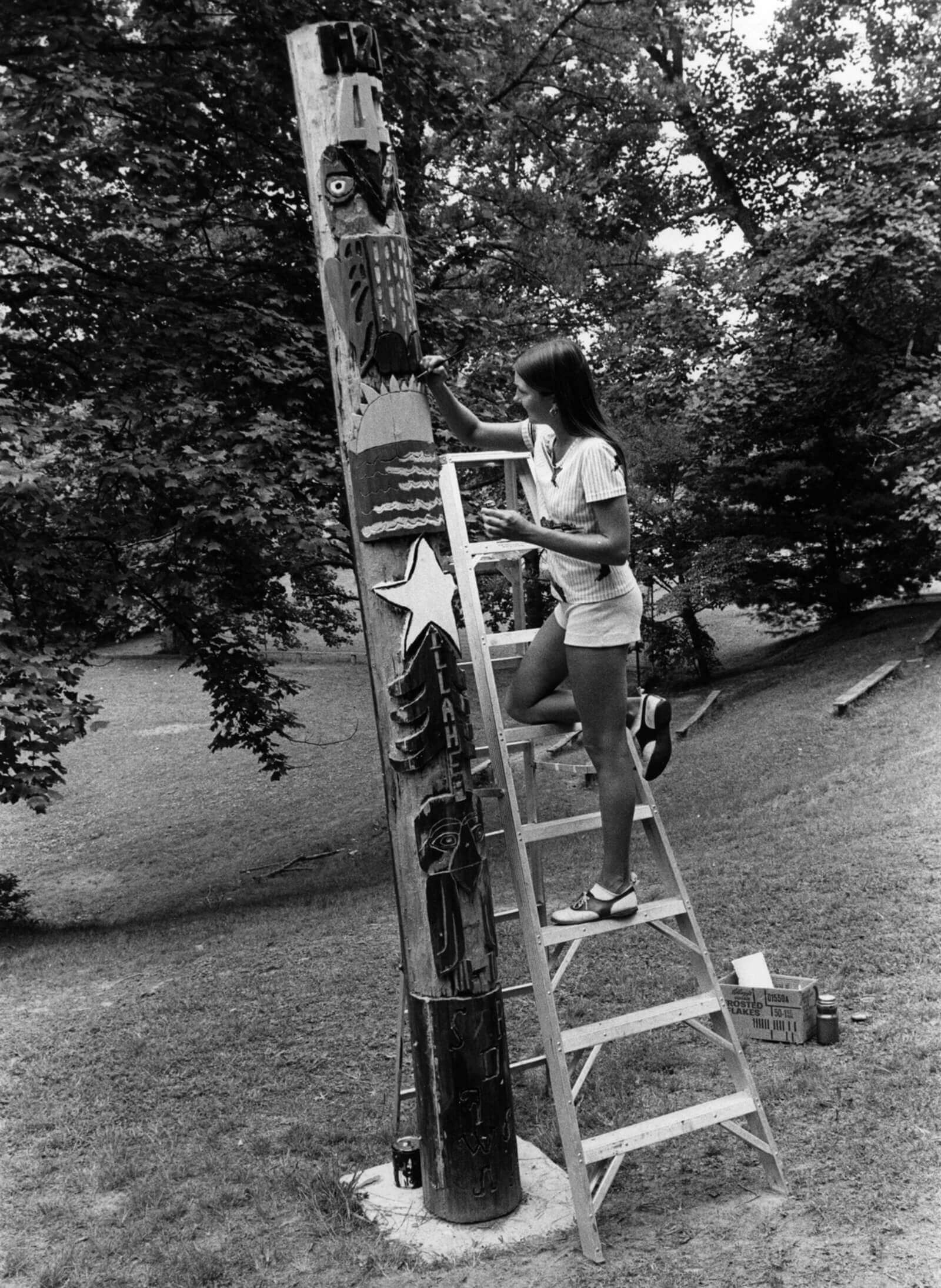 A girl decorates a “totem pole” at Camp Illahee, North Carolina, 1970s.