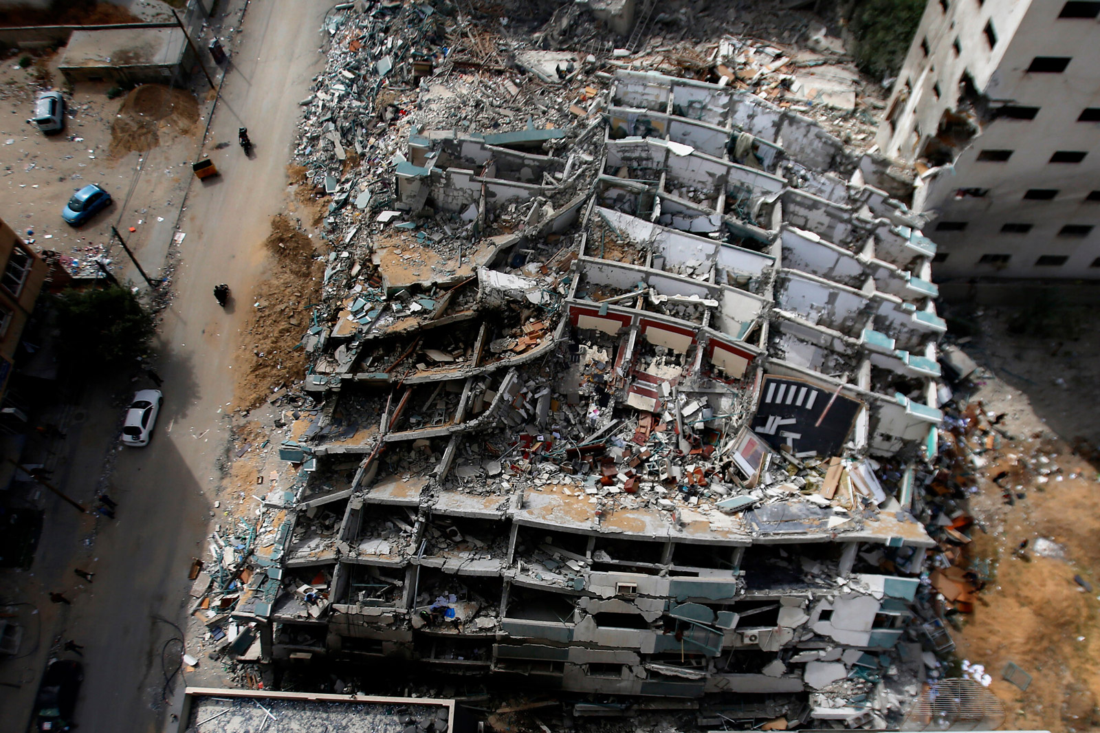 The rubble of the Jalaa Tower—the building in Gaza that housed some sixty residential apartments and the offices of AP, Al Jazeera, and a number of other media organizations—after it was bombed by Israel on 15 May 2021. According to the Israeli newspaper Haaretz, at the meeting convened to consider the legality of the strike, “Major General Sharon Afek, the military advocate general at the time, ruled that it did not violate international law. A few senior defense officials warned, however, of the PR damage the strike would cause.” Photo Hatem Moussa.
