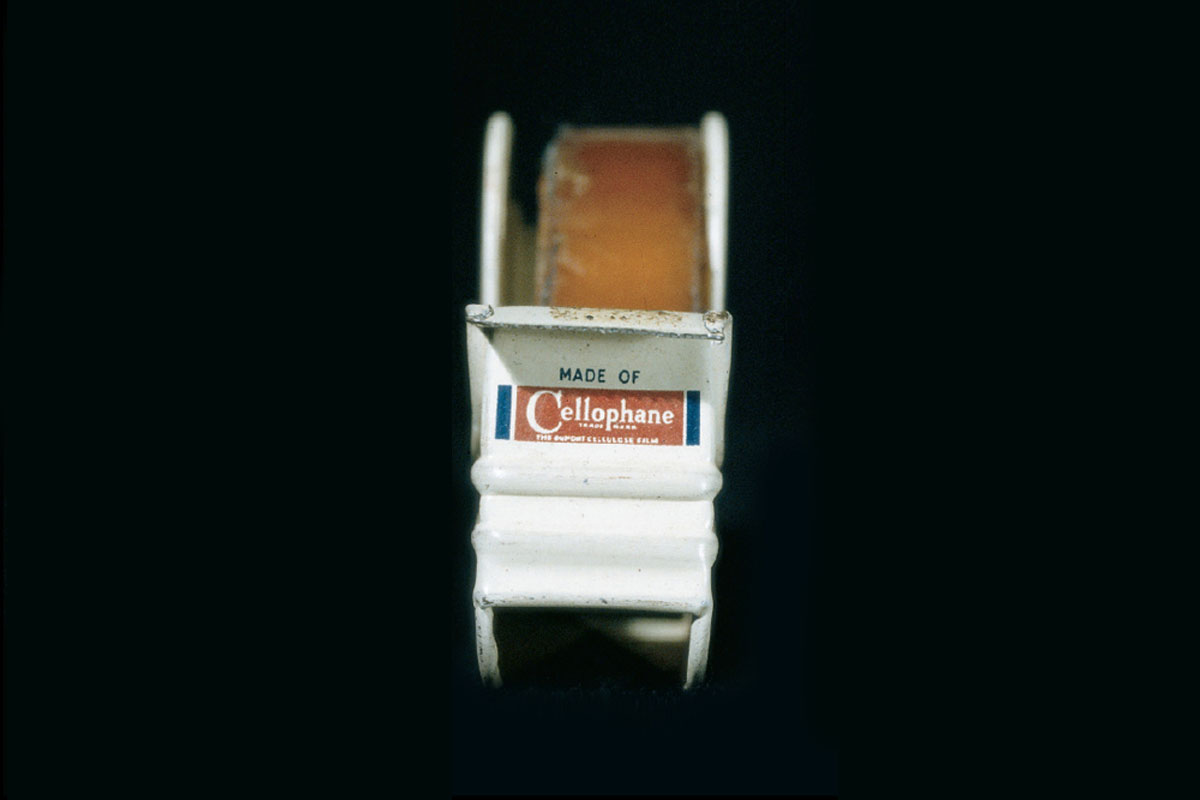 A photograph of the front of a tape dispenser from 1942 showing the words “Made of Cellophane.”