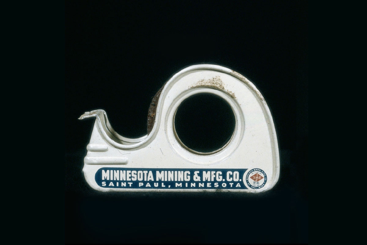 A photograph of the side of a tape dispenser from 1942 showing the words “Minnesota Mining and Manufacturing Company, Saint Paul, Minnesota.”