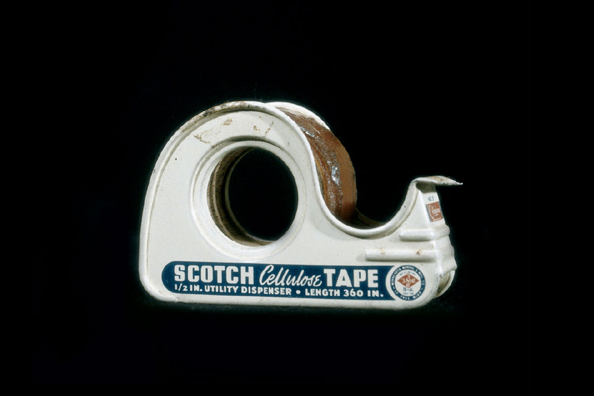 A photograph of the side of a tape dispenser from 1942 showing the words “Scotch Cellulose Tape half-inch Utility Dispenser -- Length 360 inches.”