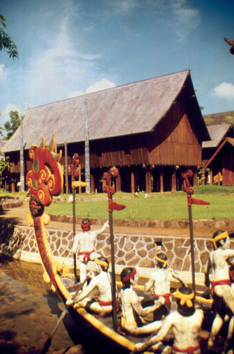 A photograph of performers in indigenous dress in a boat at Taman Mini.