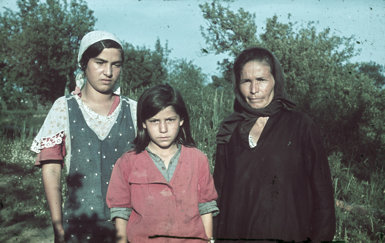 Three Romani women looking at the camera.