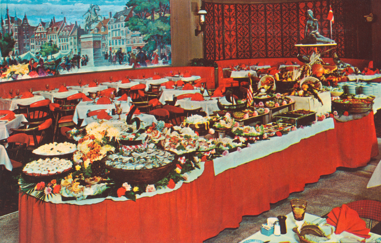 Postcard from the nineteen sixties of a buffet the Copenhagen Restaurant at the Sheraton-Plaza Hotel, Boston, Massachusetts. According to the description on the reverse, “The Little Mermaid, a symbol of the hospitality and charm of Denmark, looks down on an array of Scandinavian and American Smorgasbord specialties.”