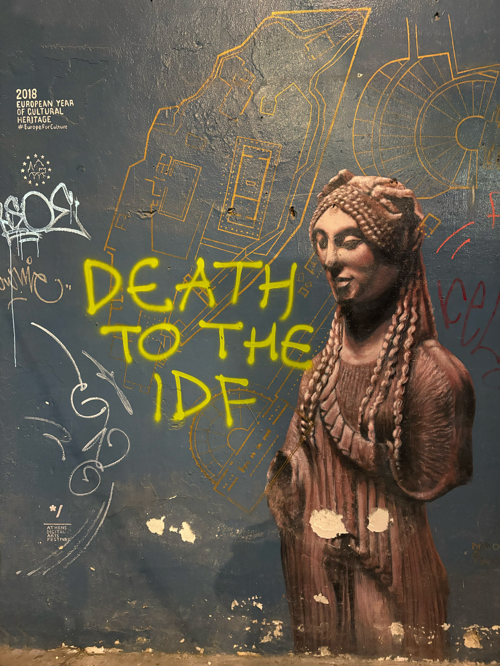 Graffiti reading “Death to the IDF” on a Hellenist mural in Athens.