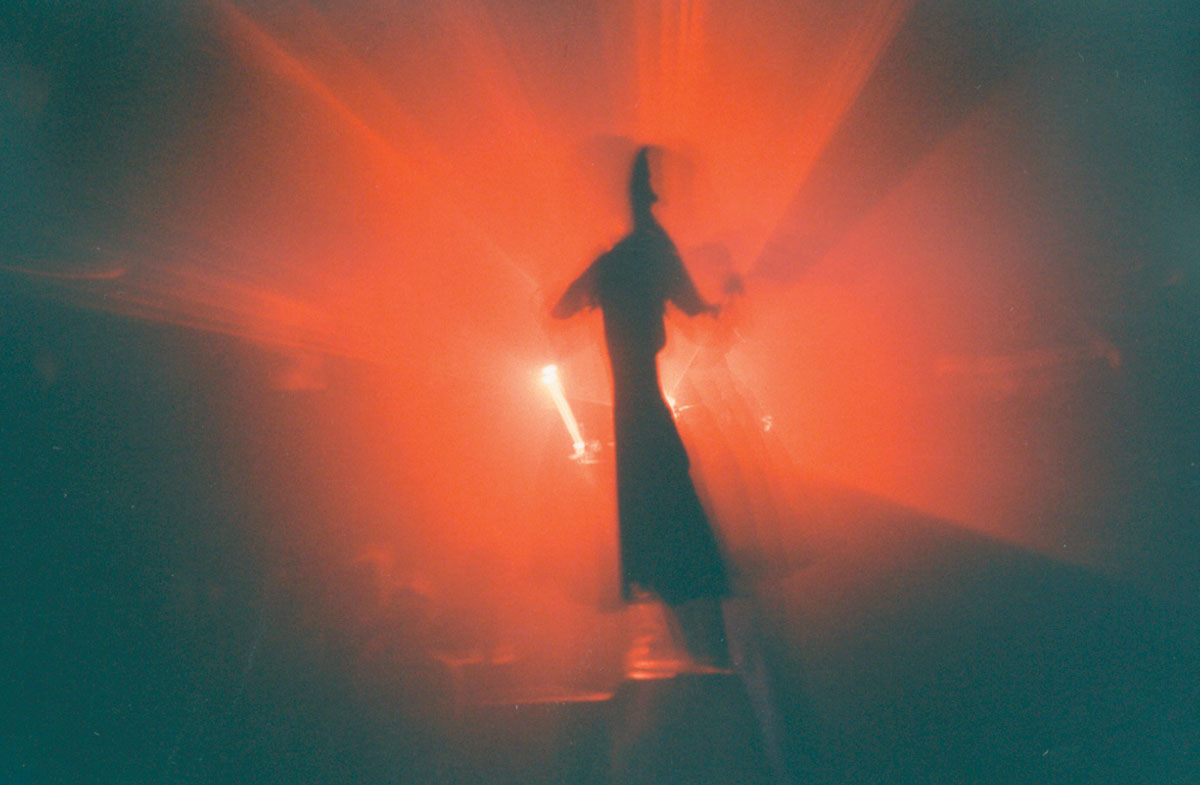A Lomographic image depicting a shadowy figure backlit with bright red light.