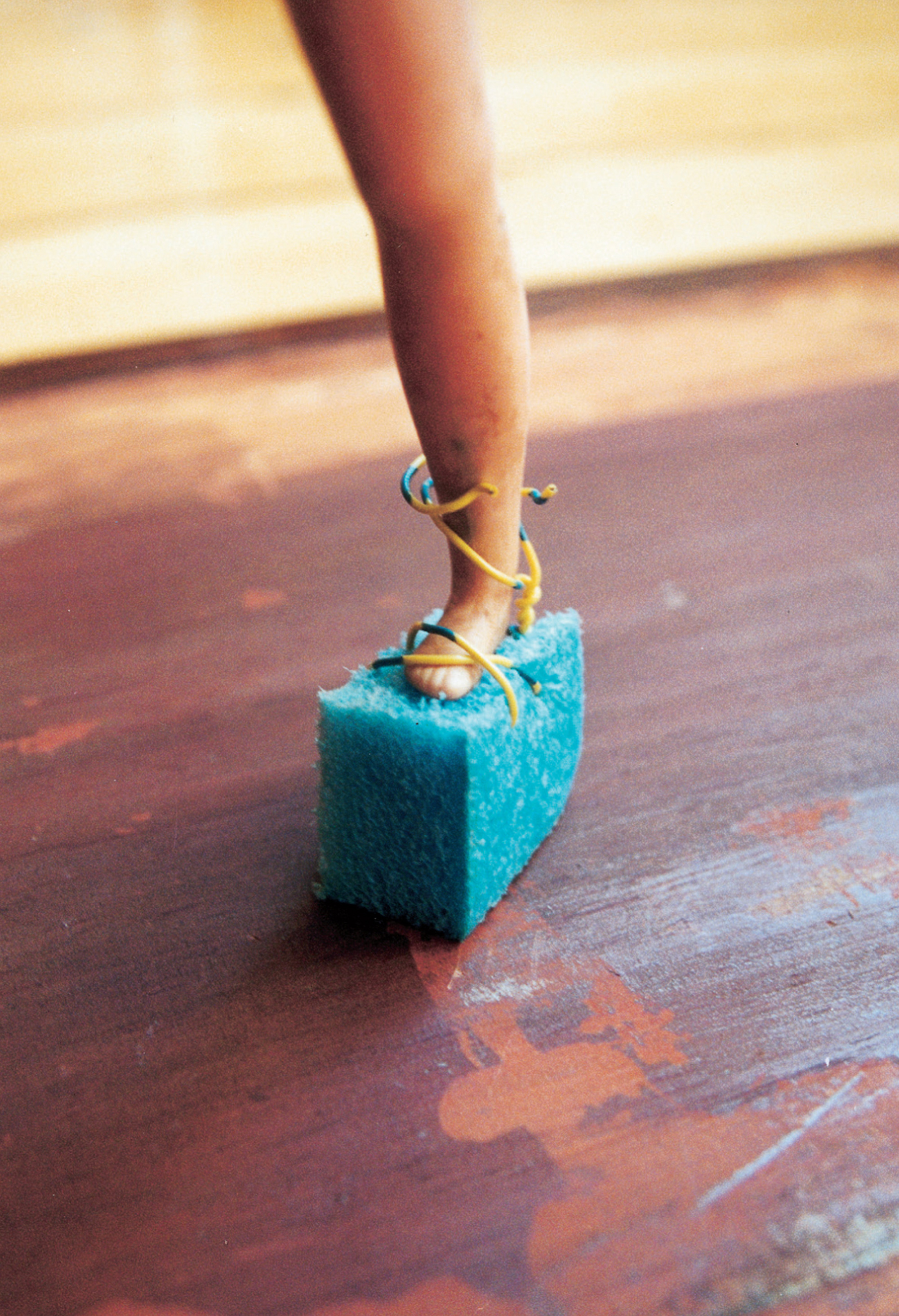 Single platform sandal of blue styrofoam with straps of yellow and blue telephone wire securing the toe with an X but loose at the ankle, up which they are possibly intended to be crisscrossed, Roman style. This artifact exemplifies the Doll Games’ strategic appropriation and ironic framing of elements of the dominant culture (in this case, popular styles of the disco era). The care put into crafting an article that would have been spurned by the Doll Games’ androgynous heroines shows the complex interplay of desire and scorn in the Doll Games’ ongoing interrogation of femininity. Just whose foot did the cobbler have in mind? Like the bewildered prince in the fairy tale, we are left with a shoe and a question.